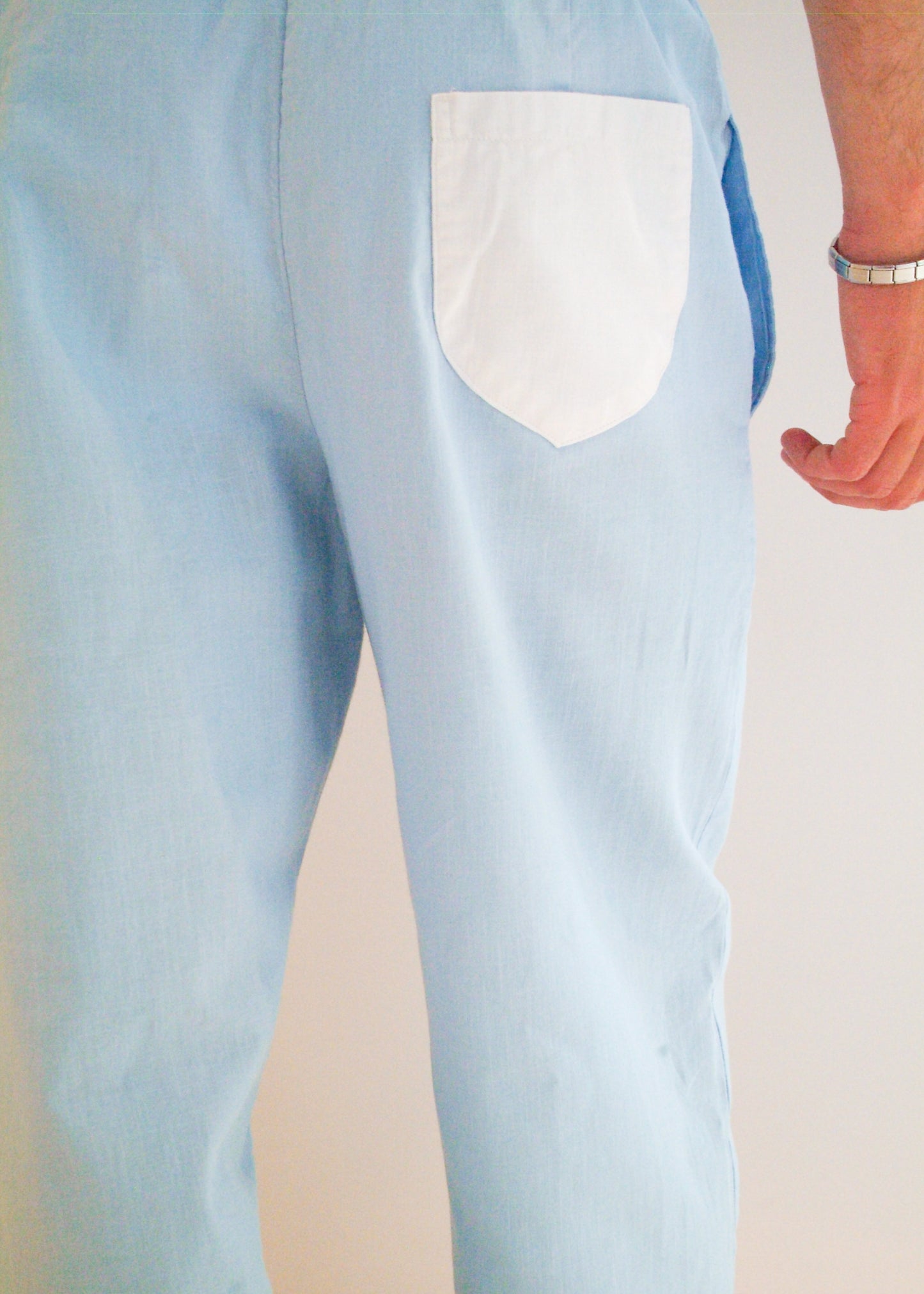 Light blue pants with a white pocket on a neutral background