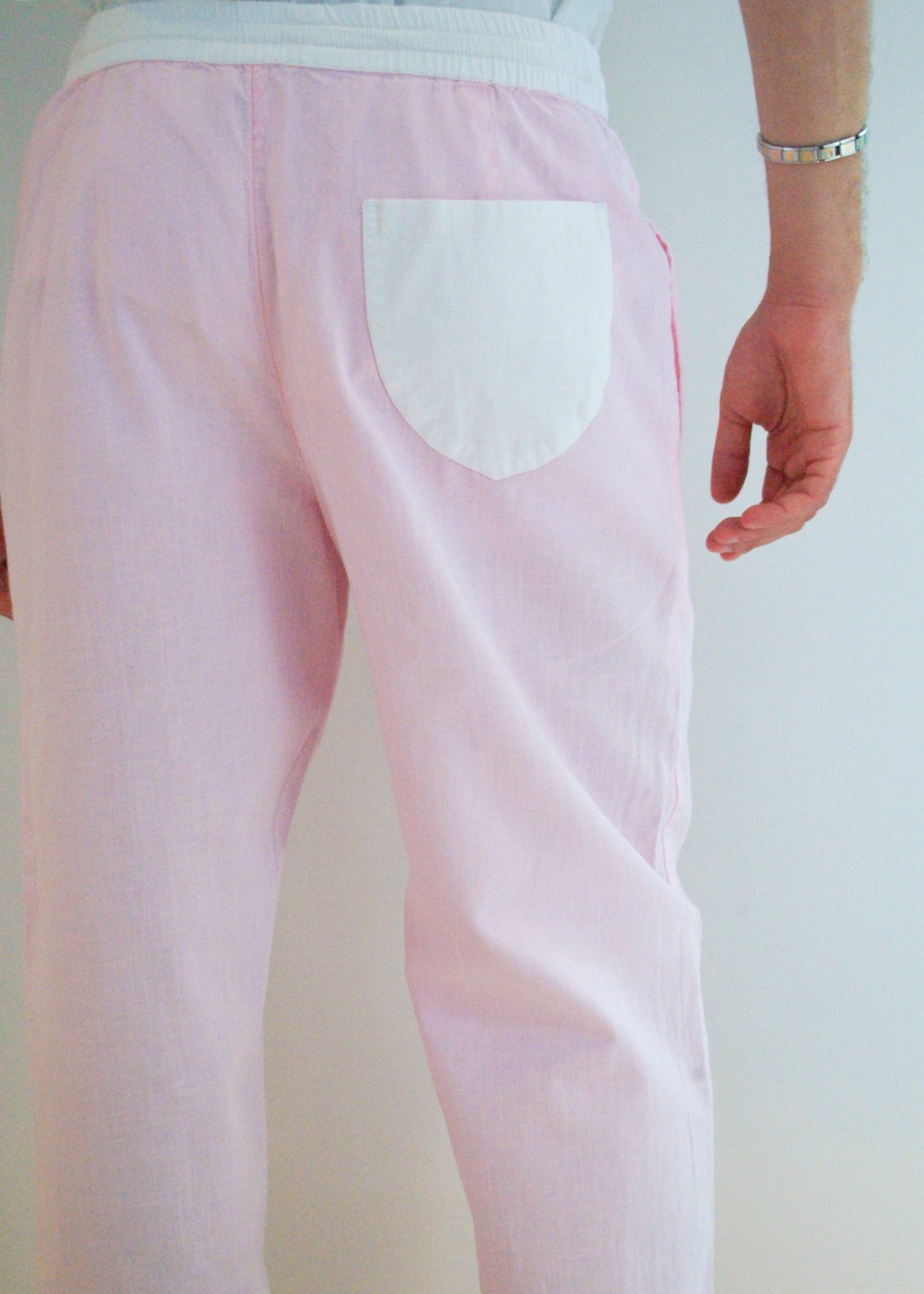 Pink pants with a white pocket on a plain background