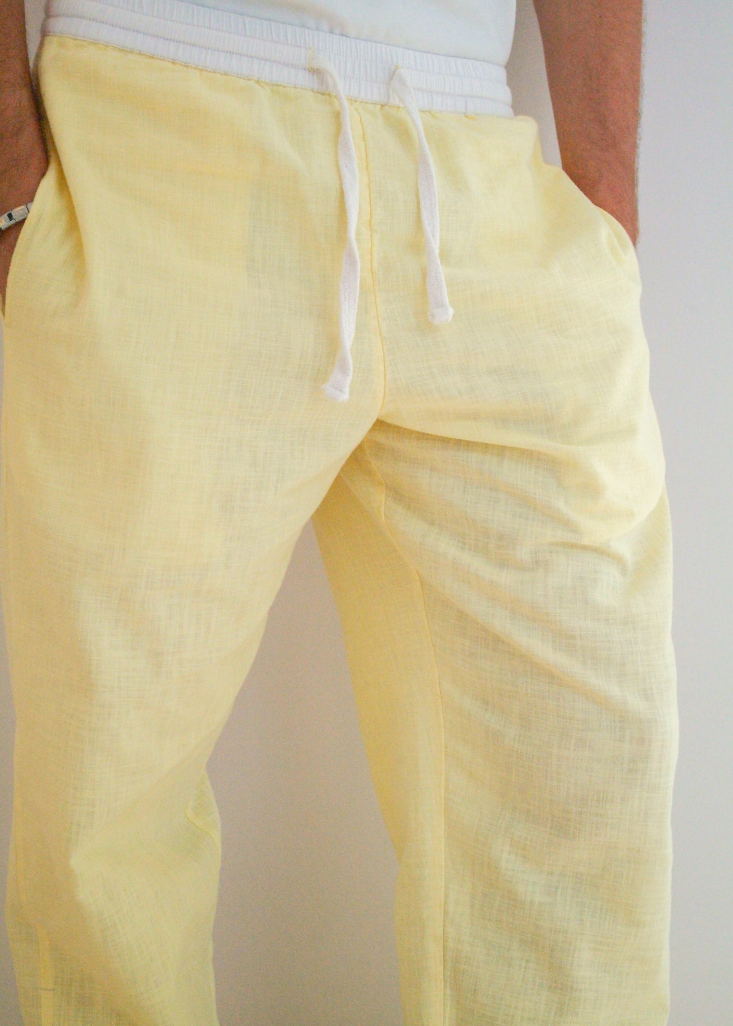Yellow pants with a drawstring on a plain background